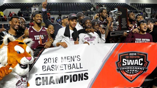 Texas Southern basketball players pose with the champion's trophy after their win over Arkansas-Pine Bluff  in the championship of the Southwestern Athletic Conference, Saturday, March 10, 2018, in Houston.