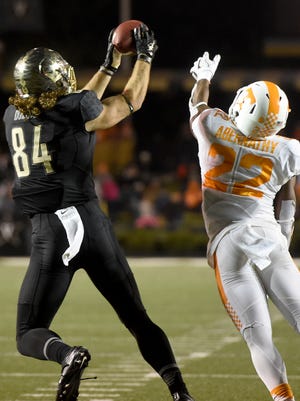 Vanderbilt tight end Sam Dobbs makes a catch in front of Tennessee defensive back Micah Abernathy on his way to a first-half touchdown in the game between Vanderbilt and Tennessee at Vanderbilt Stadium on Saturday.