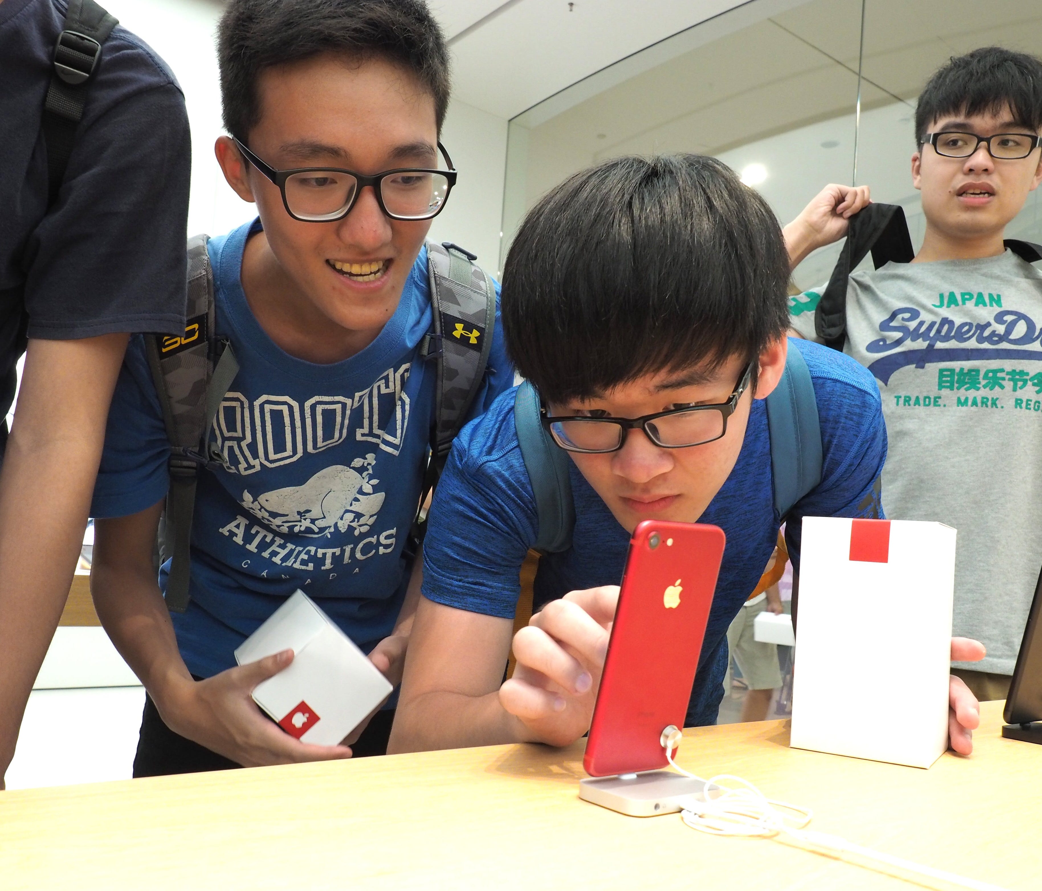 Students look at an iPhone at the Apple Store in the Taipei 101 skyscraper in Taipei, Taiwan.