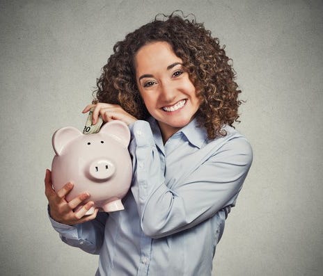 Lady smiling and holding piggy bank