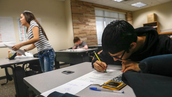 Jaden Mascarenas, right, works on his geometry homework on Friday at San Juan College High School in Farmington.
