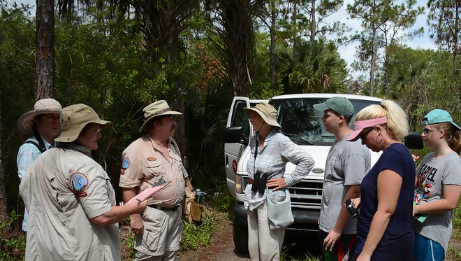 Guides Rich Kuntz and Jean McCollom, center, confer along the trail. Volunteers tramped through the woods at Corkscrew Swamp Sanctuary on Tuesday, participating in a national butterfly count.