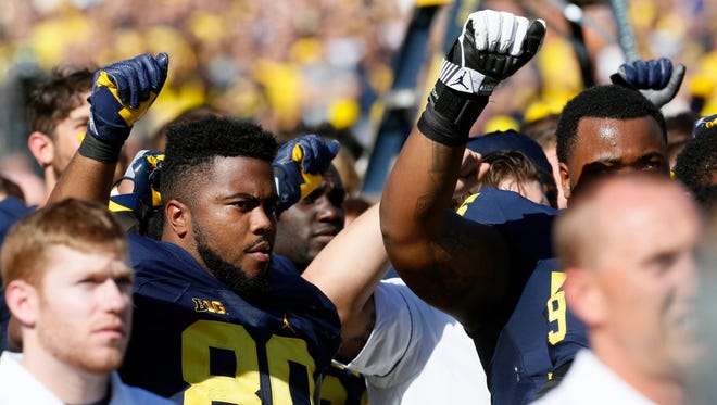 Michigan FB #80 Khalid Hill raises his fist in the air during the national anthem before the start of the game against Penn State at Michigan Stadium in Ann Arbor.