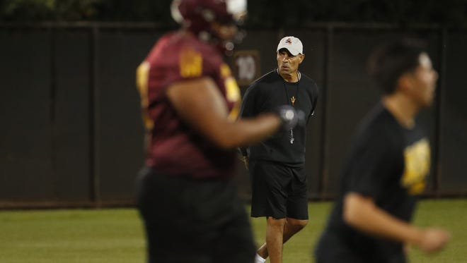 ASU's head coach Herm Edwards walks in-between offense and defense drills during a spring practice at Kajikawa practice fields on March 16, 2018 in Tempe, Ariz.