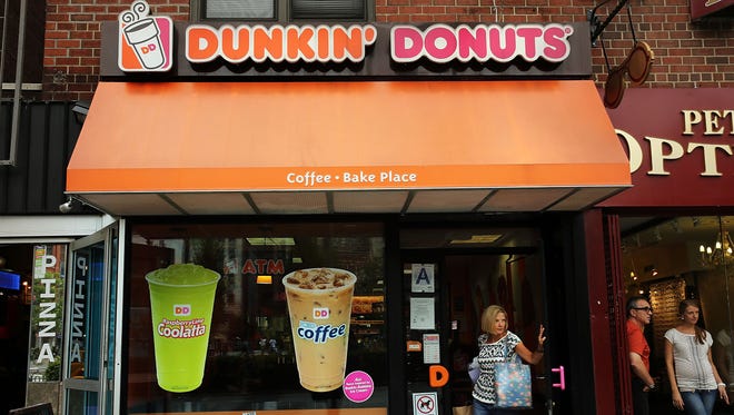 A woman walks out of a Dunkin' Donuts on July 25 in New York City.