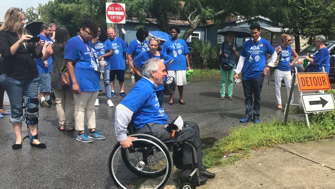 Pensacola mayoral candidate David Mayo demonstrates how a curb cut is wheelchair inaccessible on DeVilliers Street in downtown Pensacola on Thursday, July 26, 2018.