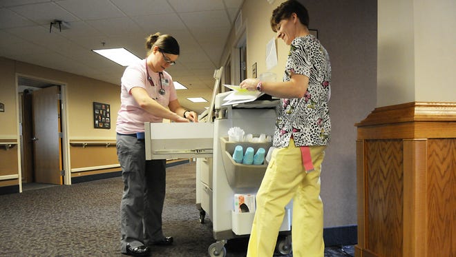 Teresa Nathan, left, and Robin Manoski count pills at the end of their shift on June 10 at Good Shepherd Community.