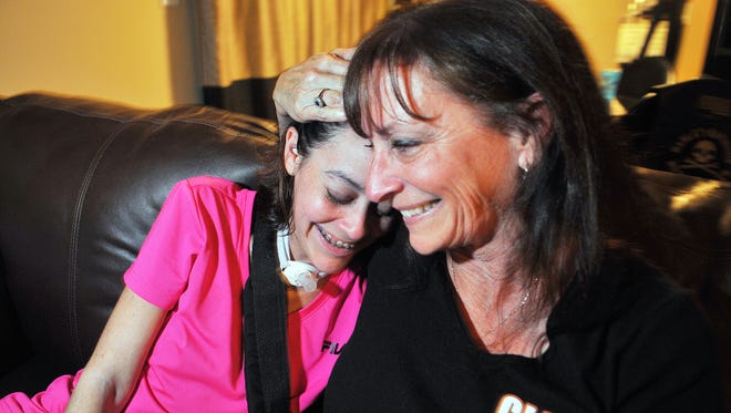 Courtney Der,  27, gets a hug from her mother, Debbie Cunningham of  Suntree. A benefit to help the Rockledge woman is at noon Nov. 21 at Pineda Inn Bar & Grill.