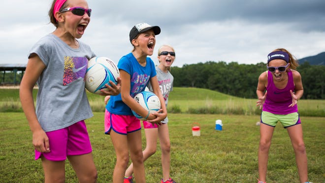 From left, Ellie Cook, 10, Keghan Marion, 10, Allison Sykes, 9, and Zoe Mader, 10, scream in excitement before the start of one of their games at Lofton Lake Volleyball Camp on Tuesday, July 21, 2015.