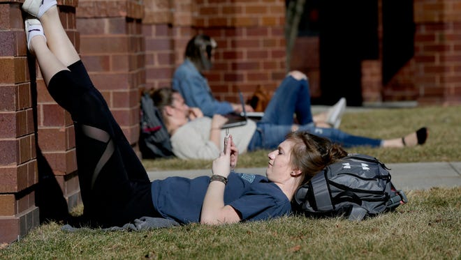 Catie Heaton, a 19-year-old Marquette University freshman from Wheaton, Ill., majoring in nursing, takes advantage of the mild temperatures as she relaxes between classes at the Alumni Memorial Union on campus on a warm day in late February.