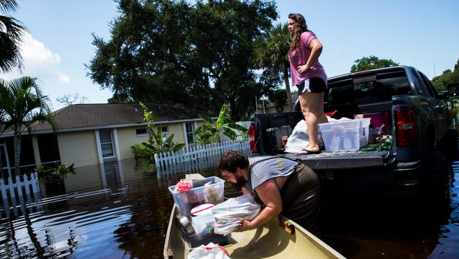 Cordell Hamilton, 21, bottom, helps Lucy Netti load her belongings into his truck as she attempts to save what she can from her flooded house in Bonita Springs on Tuesday, Aug. 29, 2017.