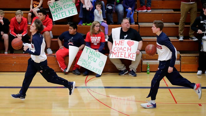 Appleton East fans hold signs supporting former head coach John Mielke during Tuesday's game in Appleton.