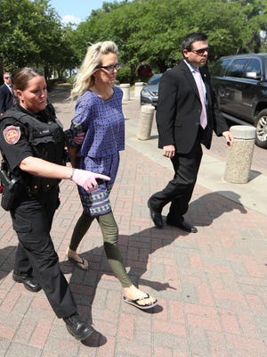 Denise Merrell Williams, 48, is led out of her accounting office at Doak Campbell Stadium in handcuffs Tuesday, after a Leon County grand jury indicted her on a charge of first-degree murder of Mike Williams.