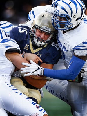 University of Memphis defender Curtis Akins (right) tackles Navy quarterback Will Worth (left) during a game in 2016.