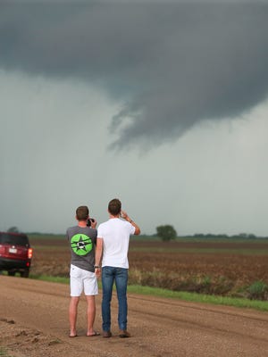 Storm chasers photograph storm clouds near Wellington, Kan., Tuesday, April 26, 2016. Thunderstorms bearing hail as big as grapefruit and winds approaching hurricane strength lashed portions of the Great Plains on Tuesday.