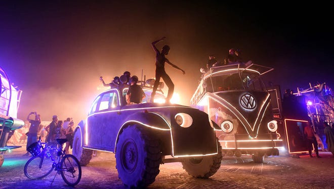 Burning Man 2017. A man dances on top of an art car on the night of the burn. 