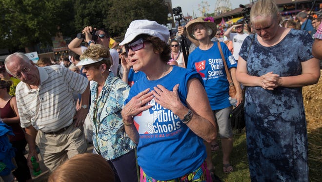 Nancy Porter of Iowa City asks questions about poverty among school children to Republican presidential candidate, Former New York Gov. George Pataki during his speech at the Des Moines Register's Political Soapbox at the Iowa State Fair in Des Moines, Iowa, Sunday, Aug. 16, 2015.