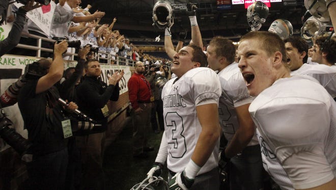 The Grand Rapids West Catholic team celebrates with their 27-14 victory over Menominee in the Division 5 final on Nov. 30, 2013 at Ford Field.