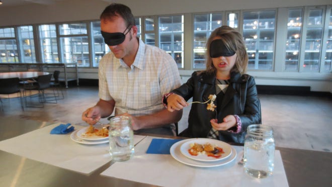 Scott Stapleton and his daughter Olivia Stapleton try to guess what they're eating while blindfolded.