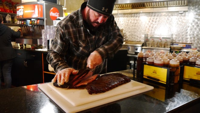 Big Mouth BBQ co-owner Sean Knox slices into a beef brisket. Big Mouth won the 2018 Greatest of Great Falls barbecue category.