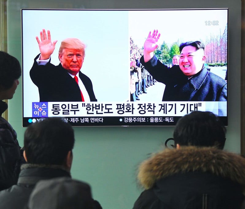 People watch a television news report showing pictures of President Trump, left, and North Korea leader Kim Jong Un at a railway station in Seoul on March 9.