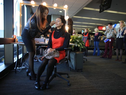 A United Airlines flight attendant has her makeup done