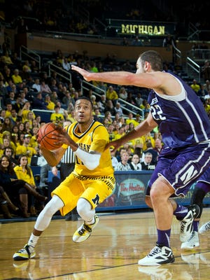 Michigan guard Muhammad-Ali Abdur-Rahkman (12) tries to get to the basket, defended by Northwestern center Alex Olah (22), of Romania, in the second half of an NCAA college basketball game at Crisler Center in Ann Arbor, Mich., Wednesday, Feb. 24, 2016. Michigan won 72-63. (AP Photo/Tony Ding)