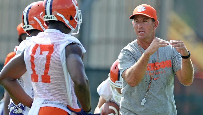 Clemson coach Dabo Swinney gives instructions to freshman wide receiver Cornell, one of 31 skill-position players competing for playing time , during the Tigers' first week of preseason practice.