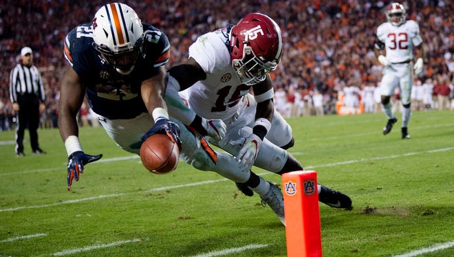 Auburn running back Kerryon Johnson (21) dives for the end zone and gets a first down as Alabama defensive back Ronnie Harrison (15) knocks him out of bounds during the Iron Bowl NCAA football game between Auburn and Alabama on Saturday, Nov. 25, 2017, in Auburn, Ala. 