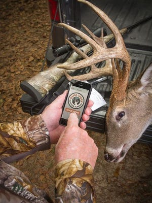 A hunter uses the "Game Check" app on the smart phone.