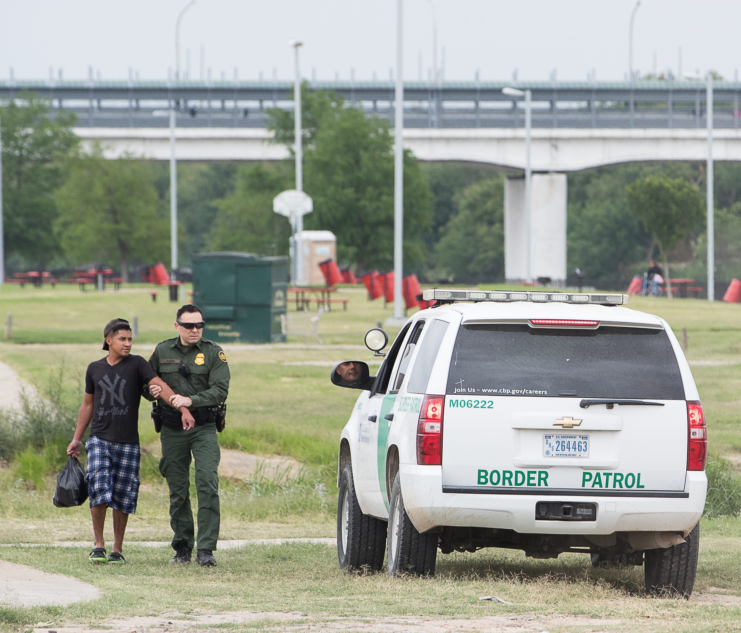 A United States Border Patrol agent catches a man along the banks of the Rio Grande after watching him illegally cross the river from Mexico into the United States in Laredo, Texas on April 9, 2018.
