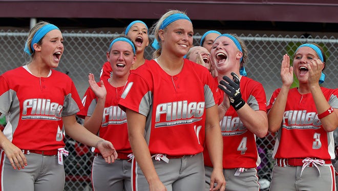 Teammates cheered as Dallas Center - Grimes pitcher Paige Lowary, center, was named captain of all tournament team after she pitched a one hitter in 5 - 0 win over Solon in Class 4-A championship game at the 2014 Girls State Softball Tournament in Ft. Dodge on Friday July 25, 2014.