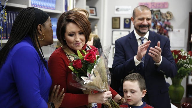 Jennifer Powell, joined by her son Easton, 5, takes congratulations after being surprised with the LCS Teacher of the Year award in her classroom at Chiles High School Wednesday.