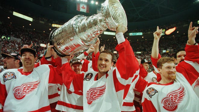 Tim Taylor (from left), Steve Yzerman and Doug Brown celebrate with the Stanley Cup after the Red Wings beat the Flyers 2-1 at Joe Louis Arena in Detroit on June 7, 1997.