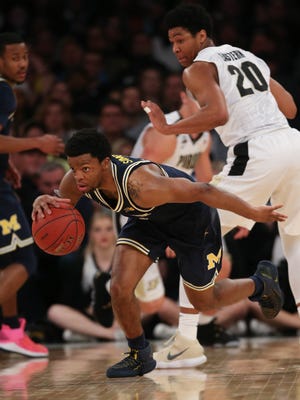 Michigan guard Zavier Simpson steals the ball from Purdue guard Nojel Eastern during second half action of the Big Ten Tournament  Championship game Sunday, March 4, 2018 at Madison Square Garden in New York.