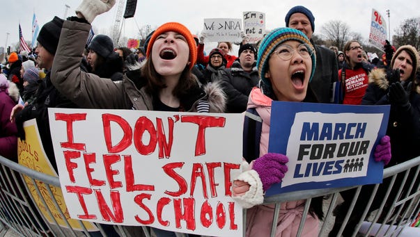 Demonstrators hold signs during a "March for Our Lives"