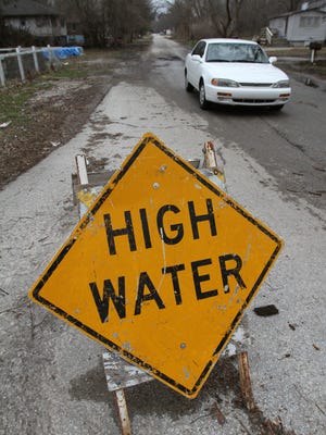 A car moves along a high water sign on Ralston in Ravenswood, Sunday, March 6, 2011.
