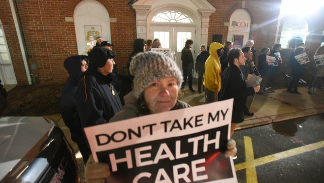 Robin Carroll of Morris Plains holds a sign during a health care advocates vigil against ACA repeal outside GOP congressional offices.