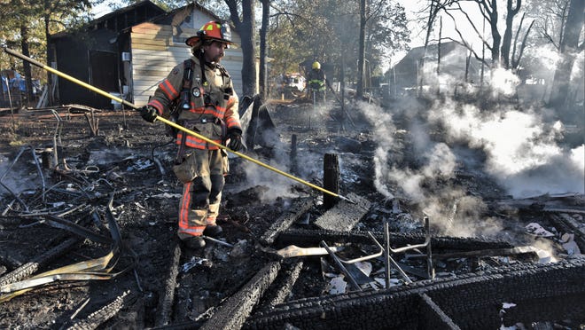 A firefighter with Bastrop County ESD No. 2 watches over the remnants of a fire on Nov. 15 in Lake Bastrop Acres. Firefighters were able to keep the blaze from spreading to bordering thick vegetation.