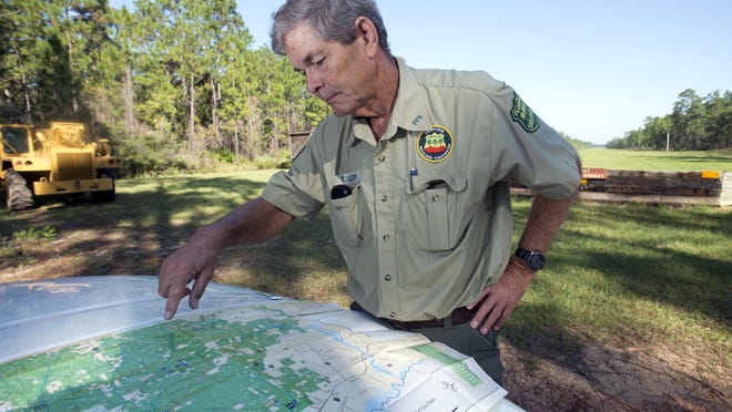 Blackwater State Forest Manager Tom Ledew maps out areas of the Munson area forest being considered by the military for training exercises beginning sometime in 2014.