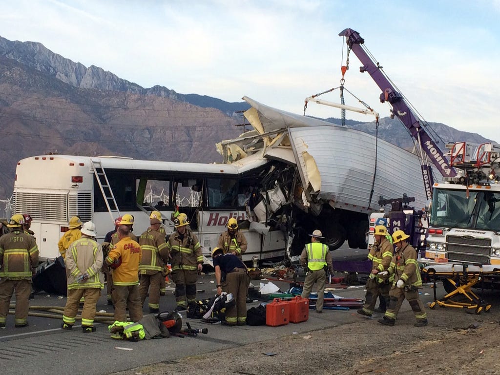 Emergency personnel work to remove victims from a tour bus crash that has killed at least 13 people. The crash occurred just after 5 a.m. along westbound Interstate 10 near Palm Springs, Calif.