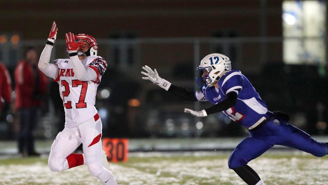 Britton/Hecla's Preston Jones (27) reaches to catch a pass as Warner's Ty McDonald (12) tries to defend late in the first half of Friday night's Class 9A playoff game in Warner.