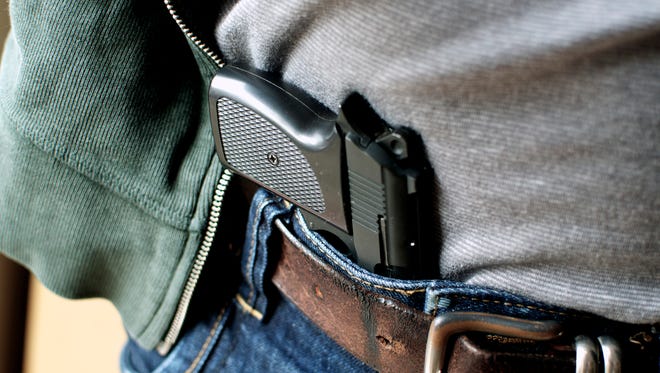Gun tucked in a belt pistol being concealed.