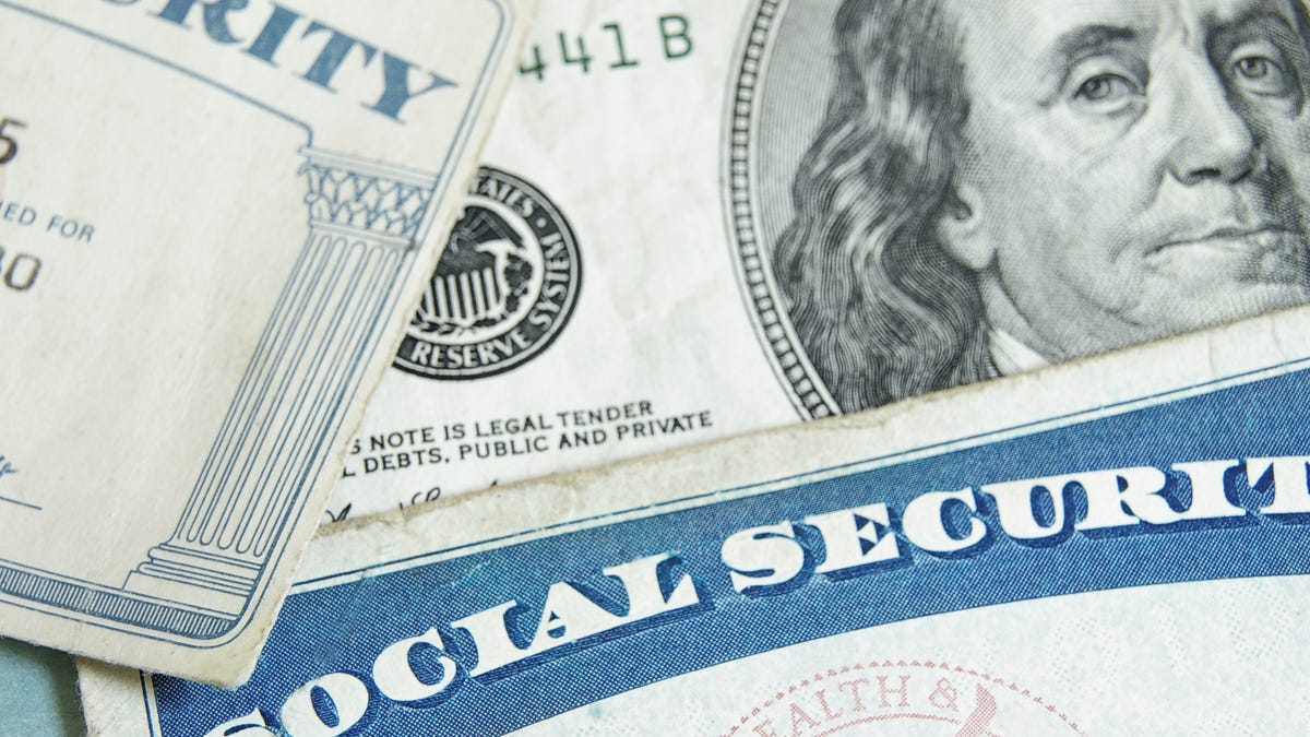 Two Social Security cards on top of a $100 bill.