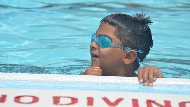 Isaac Martinez takes a break from swimming Saturday, July 11, at Bouws Pool.