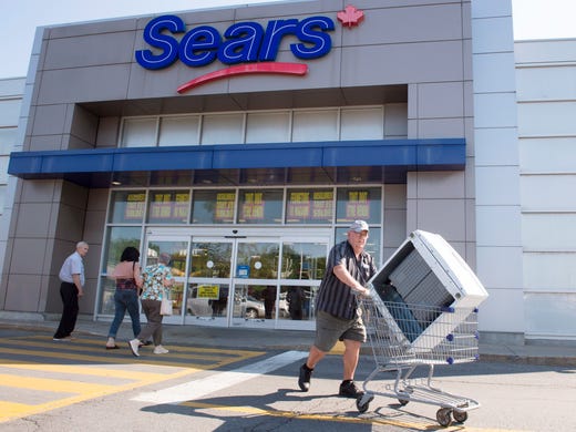 Customers enter and leave the Sears store in St. Eustache,