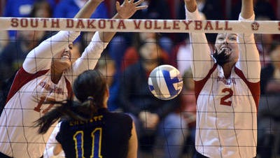USD's Sydney Dimke and Natalie Walseth miss a spike from SDSU's Wagner Larson in a Nov. 1, 2013, volleyball match at the DakotaDome. USD beat SDSU 3-1.