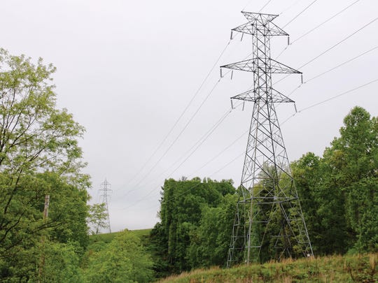 A 230 kV tower, about 135 feet tall, is pictured. Transource