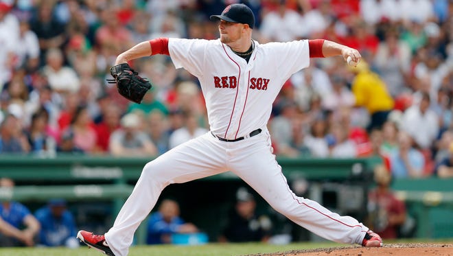 In this July 20, 2014, file photo, Boston Red Sox's Jon Lester pitches during the eighth inning of a baseball game against the Kansas City Royals,  in Boston.