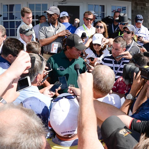 Phil Mickelson speaks to reporters after playing...